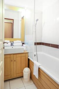 a bathroom with a tub and a sink and a toilet at Résidence Le Beach - maeva Home - 2 Pièces 5 Personnes Confort 67 in Trouville-sur-Mer