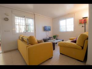 - un salon avec deux chaises jaunes et une table dans l'établissement Dream house, à Ciudad Quesada