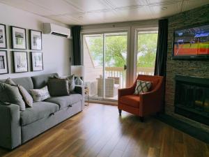 a living room with a couch and a fireplace at OMagogcondo com B in Magog-Orford