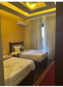 a hotel room with two beds with yellow walls at Mina Alsalam Hotel فندق ميناء السلام in Cairo