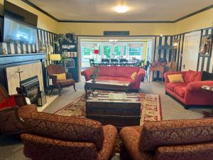 uma sala de estar com sofás vermelhos e uma mesa em Bayberry Inn B&B and Oregon Wellness Retreat em Ashland