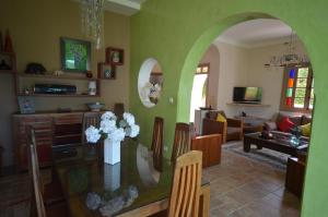 una sala de estar con una mesa de cristal con un jarrón de flores en Villa Tishka en Oualidia