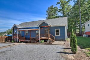 a blue tiny house with a porch and a driveway at Airy Apartment with Deck - Walk to Main Street! in Hendersonville