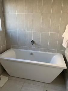 a white bath tub sitting in a bathroom at Guthulele Living in Ballito +5 photos