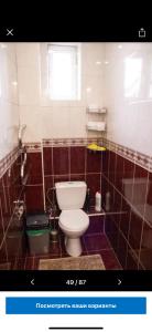 La salle de bains est pourvue de toilettes et d'une baignoire. dans l'établissement Amanat Hostel Bishkek, à Bishkek