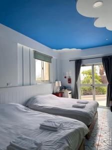 2 camas en un dormitorio con techo azul en 波斯卡朵民宿, en Magong
