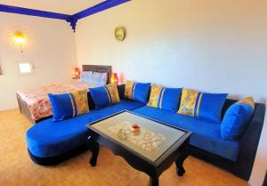 a living room with a blue couch and a table at Maison de la Lagune in Oualidia