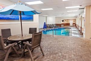 a table with an umbrella next to a swimming pool at Royal Floridian Resort South by Spinnaker in Ormond Beach