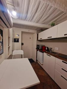 cocina con armarios blancos y mesa blanca en LEONARDO Loft NAPLES en Nápoles