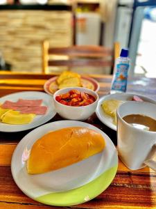 a table with plates of food and a cup of coffee at Pousada Ilha Bela in Maceió