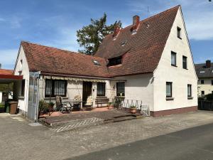 a white house with a porch and a patio at Ferienwohnung LiaWa314 mit Terrasse in Zirndorf-Lind - Nähe Playmobil FunPark und Nürnberg in Zirndorf