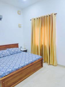 マウントラビニアにあるPapura Wattarappala Midlandのベッドルーム(ベッド1台、黄色のカーテン付)