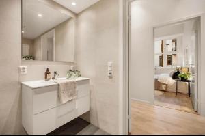 a white bathroom with a sink and a mirror at Apartment in Breiviken in Bergen