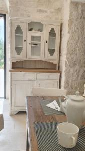 a kitchen with a table and a counter with a cupboard at Trullo Pettirosso Ostuni in Ostuni