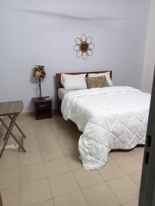 1 dormitorio con cama, mesa y espejo en Mienmo Residence, en Ouagadougou