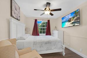 una camera con letto e ventilatore a soffitto di South Florida vacation home a Coral Springs