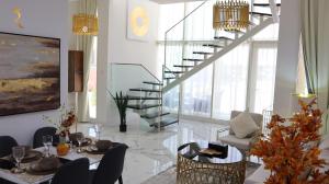 a living room with a table and chairs and a staircase at City Nest - 2BR apartment. in Abu Dhabi
