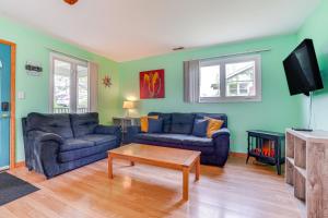 a living room with two blue couches and a tv at Kayak, Fish, Boat and Swim Home Near Lakeside Park! in Woodland Beach