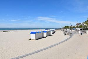 una playa con una fila de cabañas de playa en ella en Hôtel OpalOriental, en Boulogne-sur-Mer