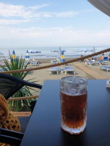 a drink sitting on a table in front of the beach at Eni's Villa, 5km From Shengjini Beach in Lezhë