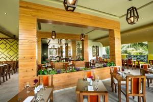 un restaurante con paredes de madera, mesas y sillas en El Dorado Maroma Catamarán, Cenote & More Inclusive, en Playa del Carmen