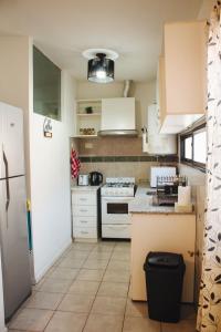 门多萨Acacia的配有白色橱柜和台面的厨房 更多3张照片