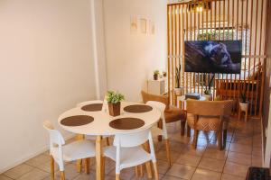 una sala da pranzo con tavolo e sedie bianchi di Acacia a Mendoza