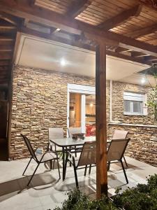 a patio with a table and chairs and a brick wall at Nouli's Mountain View Haven in Nikiti