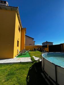 un edificio amarillo con un patio con piscina en El Mirador de Segovia, en Basardilla