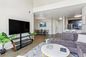 Modern 2bedroom Apartment with Pool في لوس أنجلوس: غرفة معيشة مع أريكة وتلفزيون بشاشة مسطحة