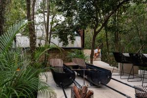 プエルト・モレロスにあるGlass Houseの椅子と屏風のある庭を歩く女