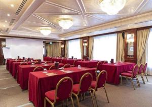 uma sala de conferências com mesas e cadeiras vermelhas em Hotel Impérial em Libreville