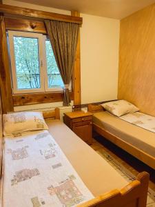 two beds in a room with a window at Apartman Olivera in Žabljak