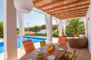 a dining room with a table and chairs and a pool at Villa Fustera by Abahana Villas in Benissa
