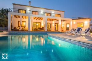 a villa with a swimming pool in front of a house at Villa Fustera by Abahana Villas in Benissa
