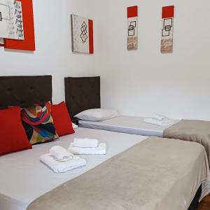 Dos camas en una habitación con toallas. en Pousada irmãos Oliveira en Lindóia