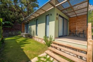 a house with a wooden deck with a patio at Sea Valley Lodge in Faralya