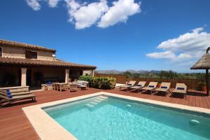 - une piscine avec des chaises et une maison dans l'établissement Ca Sou Alcudia, à Alcúdia