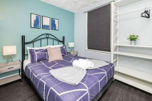 1 dormitorio con cama morada y ventana en Pet-Friendly Home - Near Chinatown & Little Italy, en Ottawa