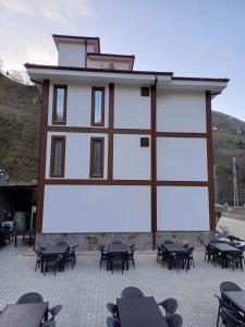 um grande edifício branco com mesas em frente em ÇARDAK ALTI OTEL em Trabzon