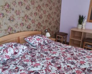 1 Schlafzimmer mit einem Bett mit Blumenbettdecke in der Unterkunft Domačija Bubec in Ilirska Bistrica
