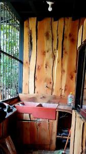 um quarto com uma parede de madeira com uma mesa e uma janela em SL Hostel em Alajuela