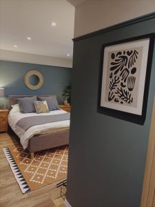 布里斯托的住宿－Warm and Homely 4BR | Parking | WiFi | Garden，卧室配有一张床,墙上挂着一幅画