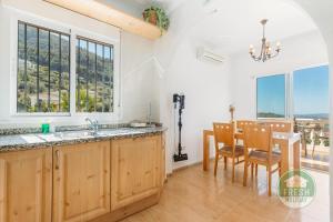 アルカウシンにあるVilla Mirador - Lovely villa in Alcaucínのシンクとテーブルと椅子のあるキッチン