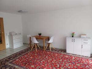 eine Küche mit einem Tisch, Stühlen und einem Teppich in der Unterkunft Naturerlebnis Ferienhaus in Neunkirchen
