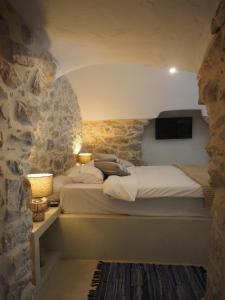 a bedroom with a bed in a stone wall at Sophia Areopoli Guesthouse in Areopoli