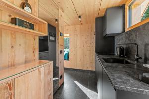 a kitchen with wooden cabinets and a sink at NEW OPENING "Sissi Chalets" - Unique Luxury Hideaway with Mountain view & Sauna in Mendola