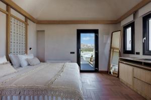 een slaapkamer met een groot bed en een balkon bij Aja Retreat Luxury Suites in Kamari +8 foto's