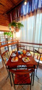 einen Holztisch mit Essen auf einem Zimmer in der Unterkunft Pousada Casa das Flores Camburi in Camburi