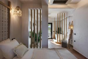 ein Schlafzimmer mit einem Bett und einen Flur mit einem Bad in der Unterkunft Aja Retreat Luxury Suites in Kamari
